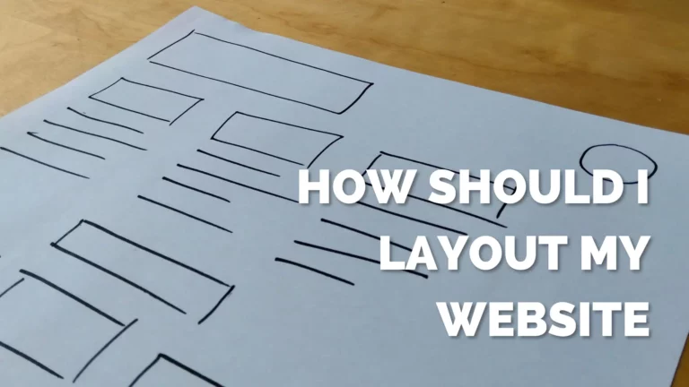 a4 paper with website wireframe sketched out with black marker on wooden desk
