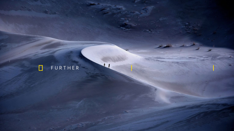 National Geographic branded image of people walking in the snow with tagline further